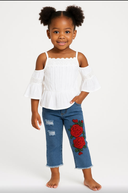Young girl wearing a white top and blue jeans with floral designs on a white background