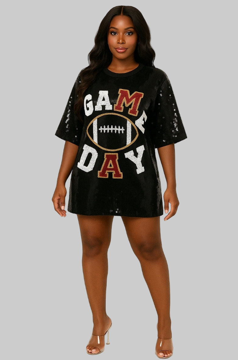 A woman standing, wearing a black dress with 'GAMEDAY' sequin lettering and a football graphic in the center.