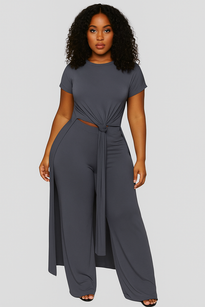 Woman wearing a gray jumpsuit on a plain background