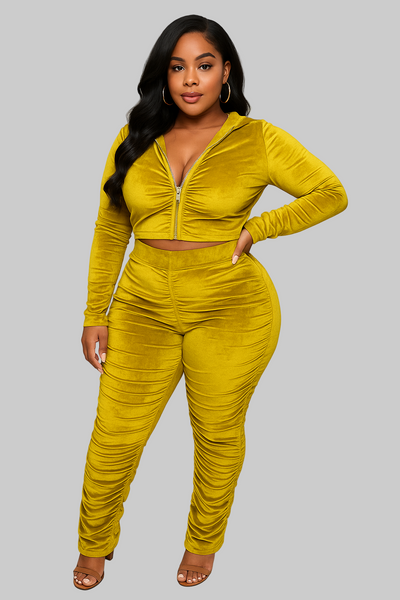 Woman wearing a yellow velvet outfit on a plain background