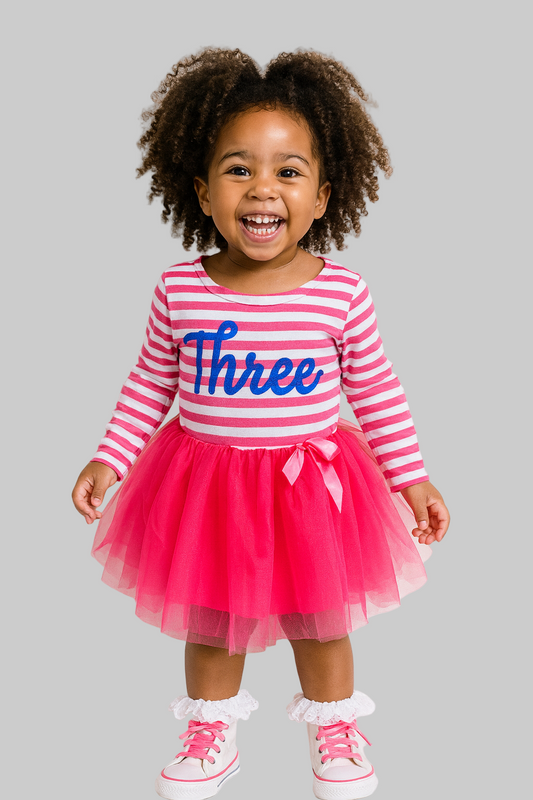 Child wearing a pink and white striped dress with a tutu and 'Three' print on a white background
