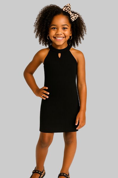 Young girl wearing a black dress with a leopard print bow on her head against a white background