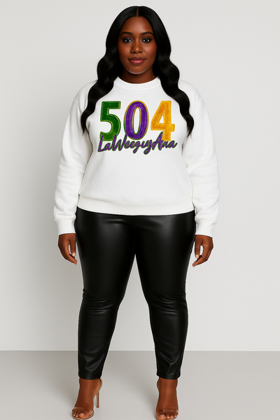 Woman wearing a white sweatshirt with colorful text and black leather pants on a plain background