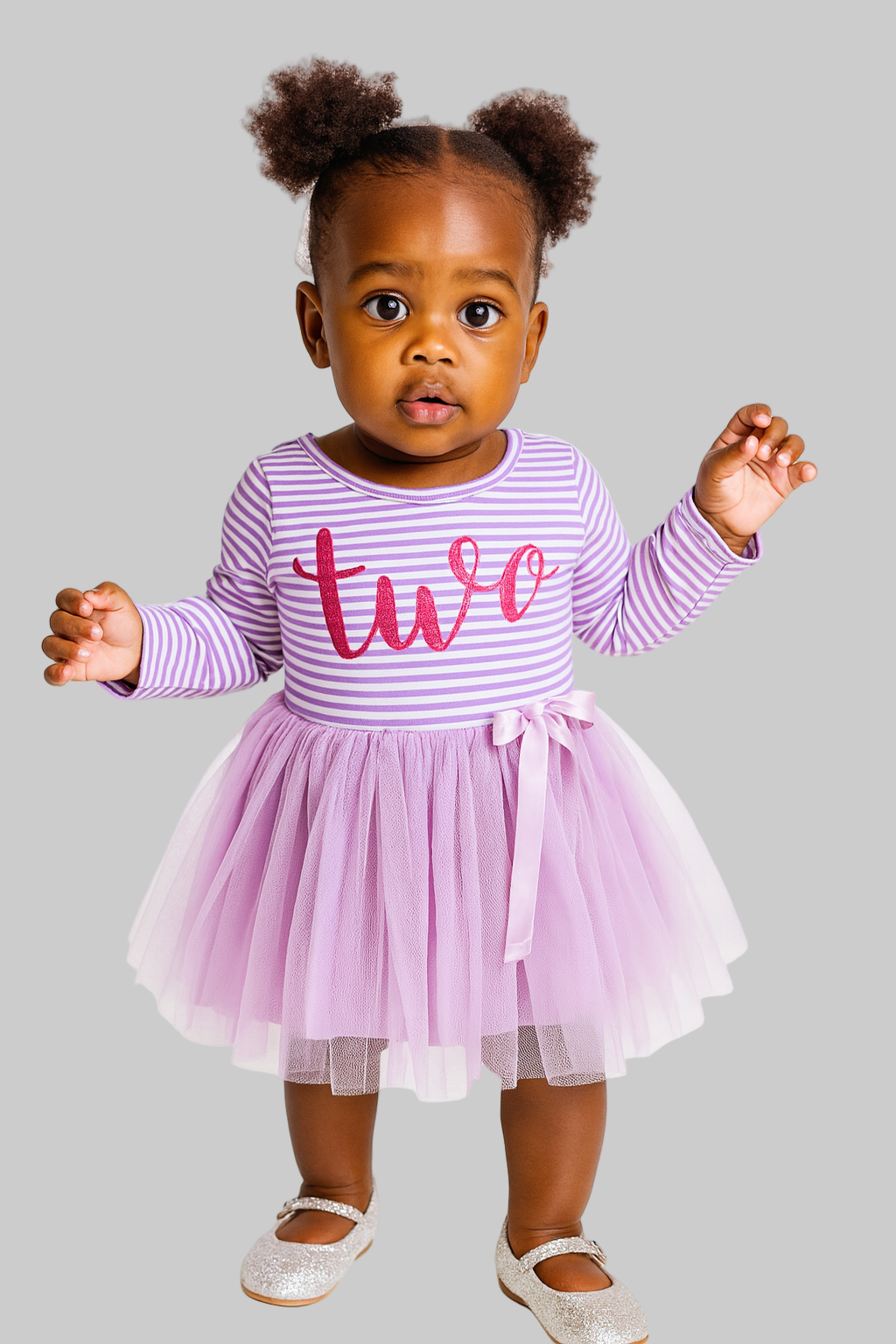 Child wearing a purple and white striped shirt with 'two' on it and a pink tutu skirt.