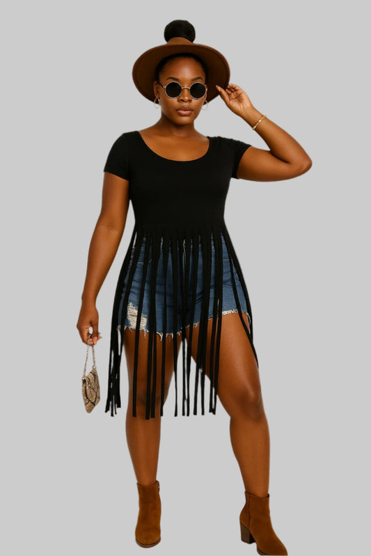Woman wearing a black fringe dress with denim shorts on a white background