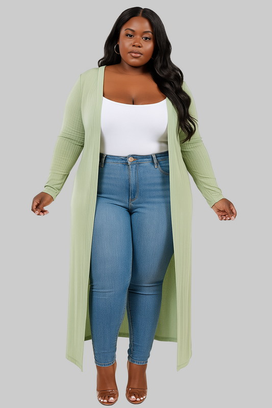 Woman wearing a long green cardigan, white top, and blue jeans on a white background