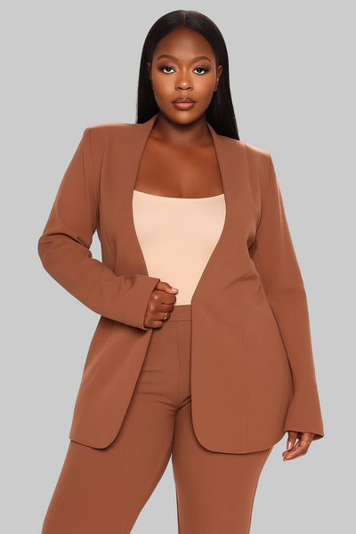 Woman wearing a brown suit with a beige top on a gray background