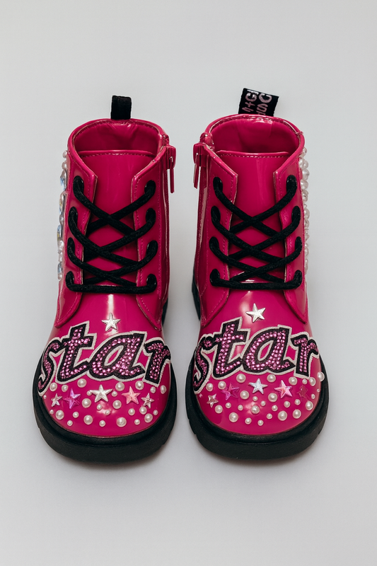 Pair of pink boots with star design and black soles on a white background