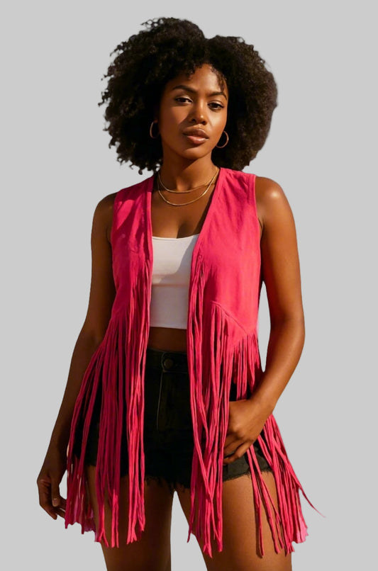 A woman wearing a sleeveless pink fringe suede vest with a white top and black shorts.