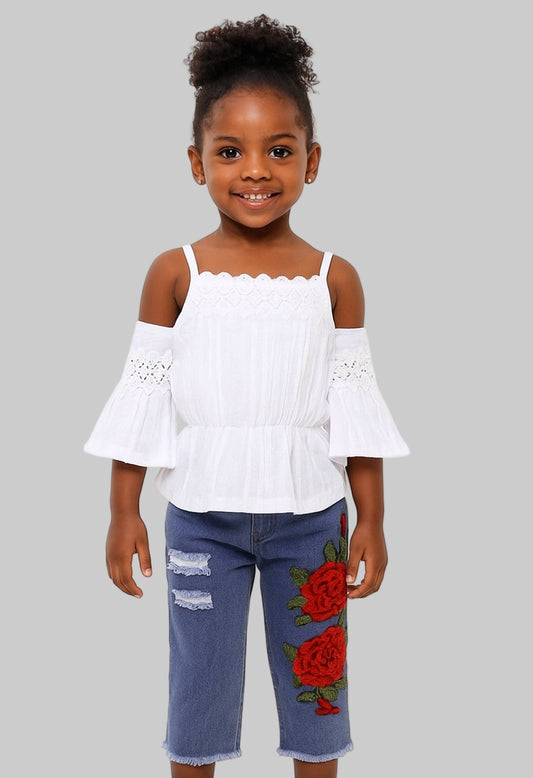 Young girl wearing a white off-shoulder top and blue jeans with floral designs on a white background