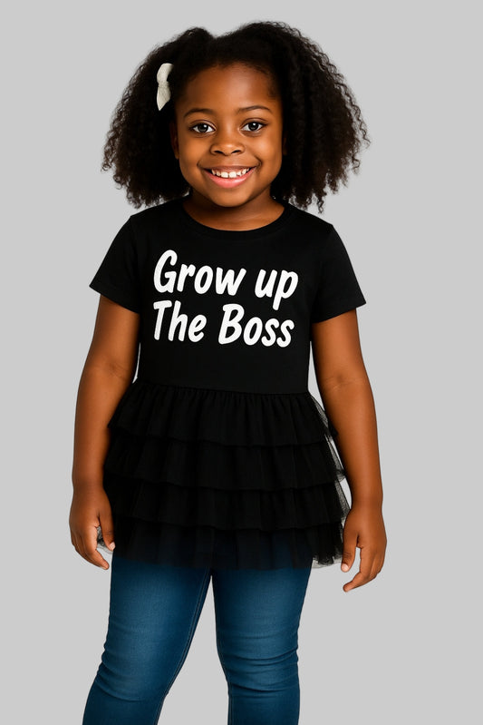 Child wearing a black t-shirt with 'Grow up The Boss' text on a white background