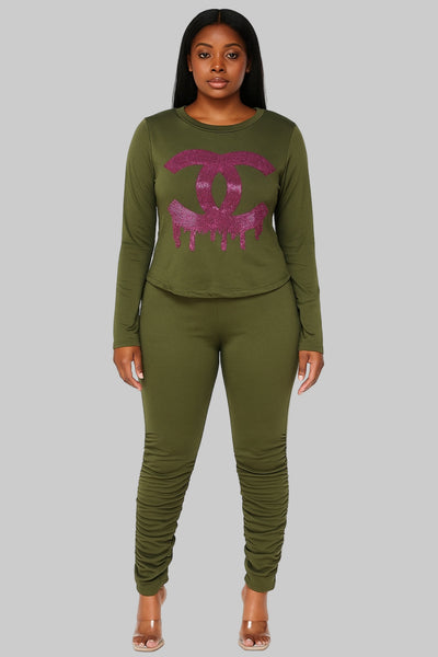 Woman wearing an olive green outfit with a pink logo on a white background