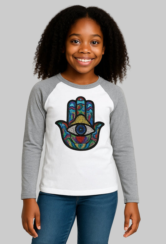 Child wearing a long-sleeve shirt with a colorful Hamsa hand design on a white background