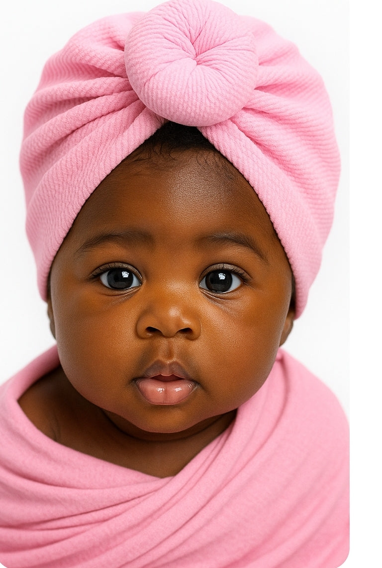 Baby wrapped in pink fabric with a pink headscarf on a white background