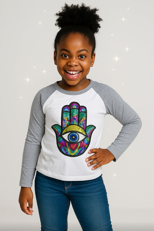 Child wearing a colorful Hamsa hand design shirt with gray sleeves on a light gray background