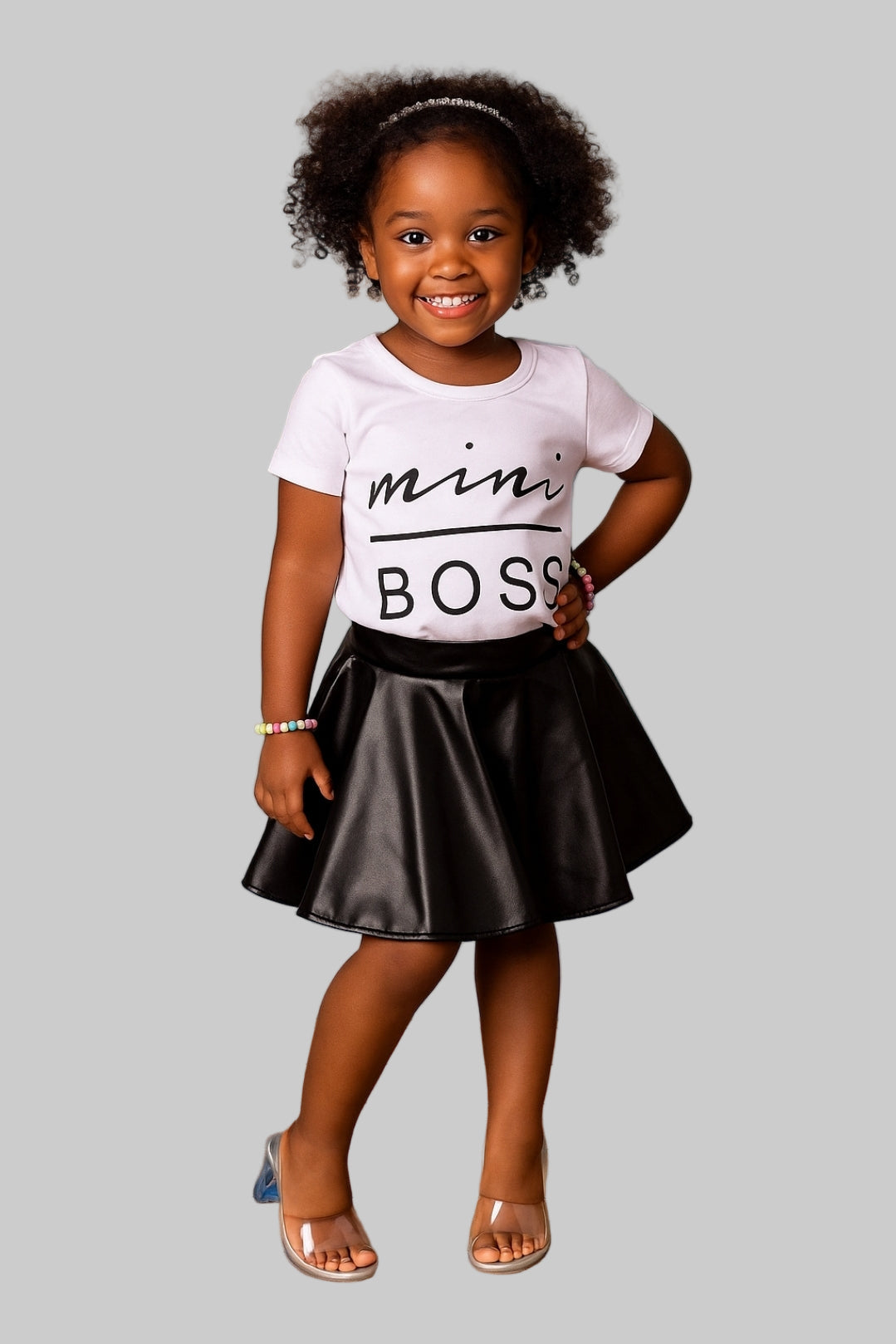 Child wearing a 'mini boss' t-shirt with a colorful background