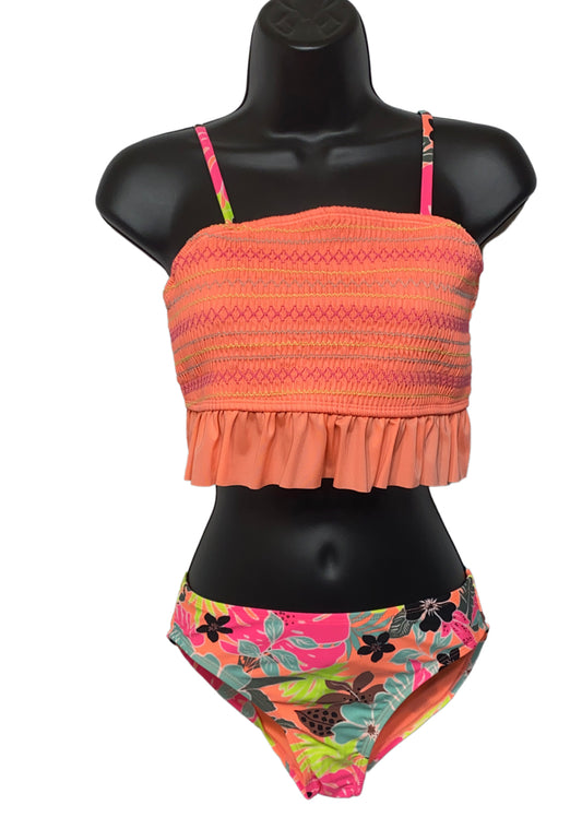 Girls' tropical two-piece swimwear with orange and pink colors and a floral pattern on the bottoms, displayed on a mannequin.